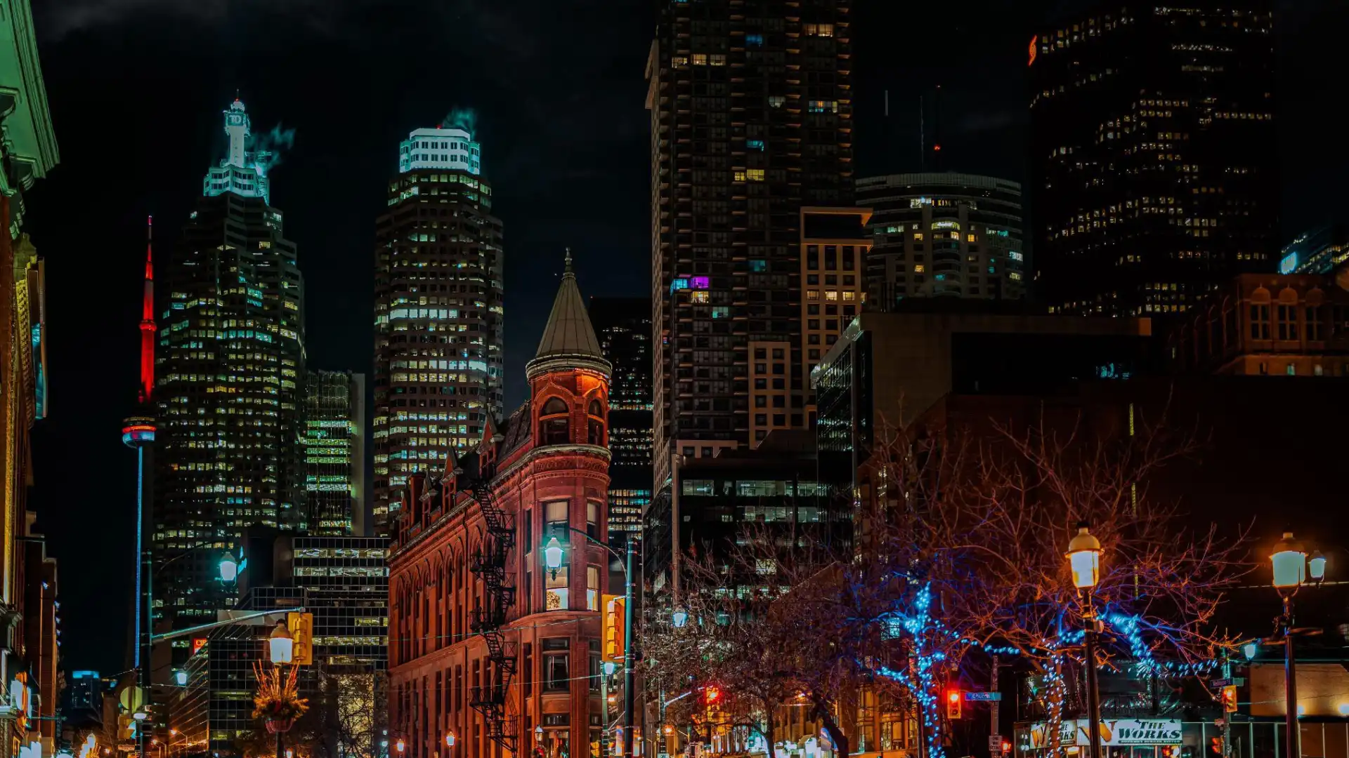 Historic Gooderham Flatiron Building and downtown Toronto towers at night with warm street lighting, an atmospheric lighting reference for cinematic render post-processing